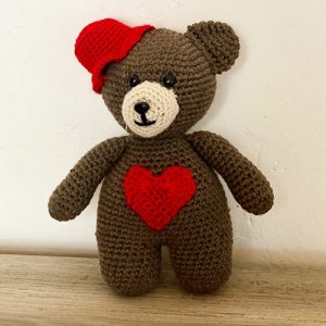 Amigurumi crochet brown bear holding a heart