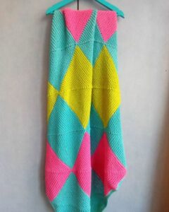 Bright pied hand knitted baby blanket