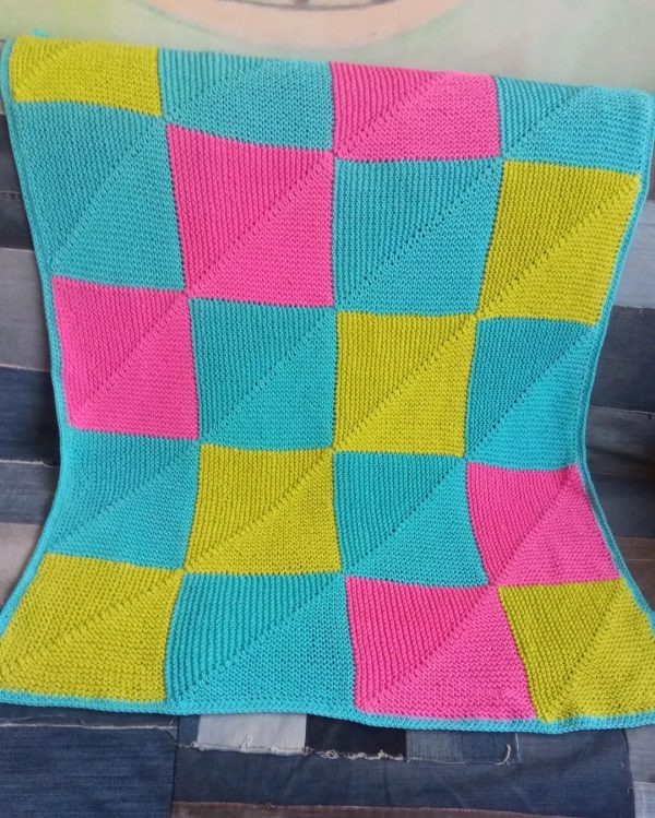 Bright pied hand knitted baby blanket