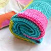 Bright pied hand knitted baby blanket