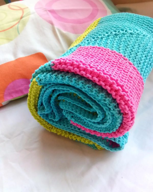 Bright pied hand knitted baby blanket